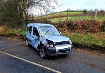 Firefighters deal with car on its side blocking the road
