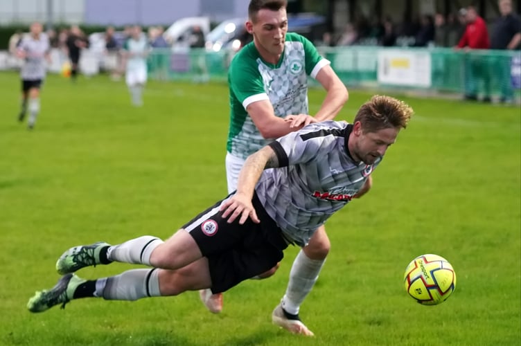 Bovey centre-back Lee Hildreth goes to ground under pressure from Jordan Ewing.