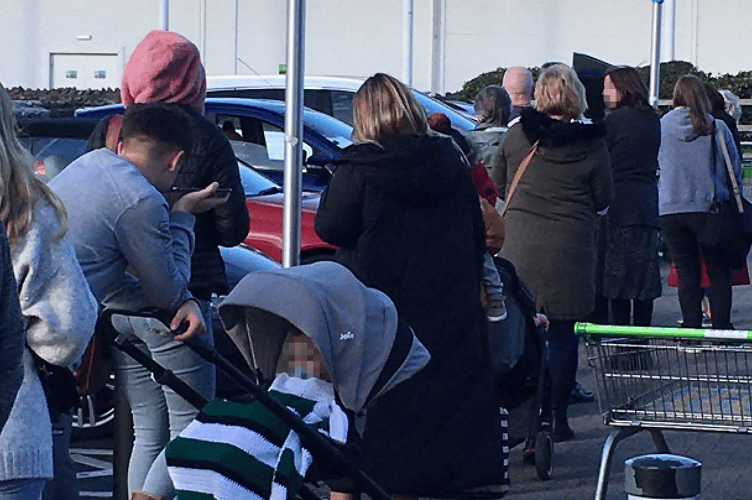 Disgruntled shopppers queueing to buy tickets.
