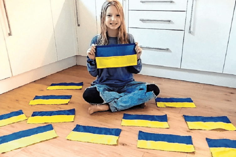 Charlotte Saunders makes flags for Ukraine funds.