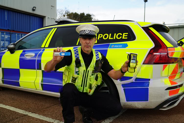 Sgt Owen Messenger with a drug wipe and breathalyser device
