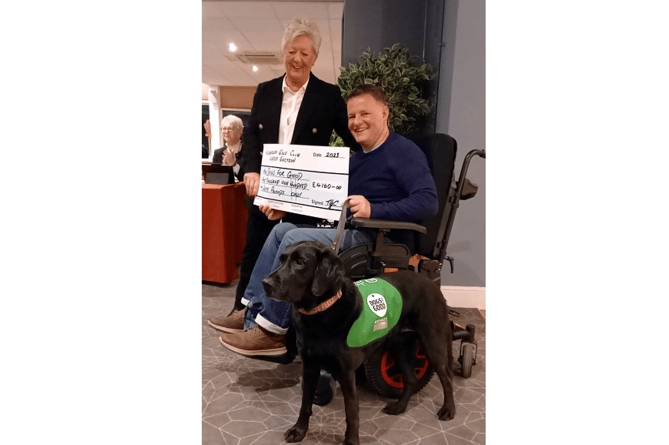 Maxine is pictured handing over a cheque for £4,160 to Dogs for Good representative, Jamie Sutherland, and his assistance dog, Hettie.
