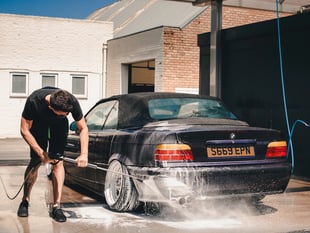 Young farmers on hand with bucket and sponge for charity car wash