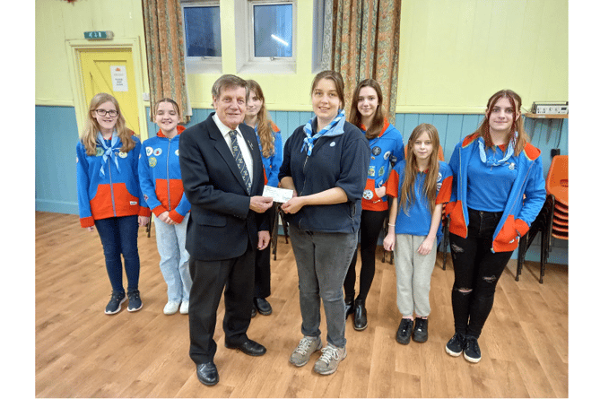 1st Teignmouth Guides receive a cheque from Tony Vile. With them is Rosie Gitsham.