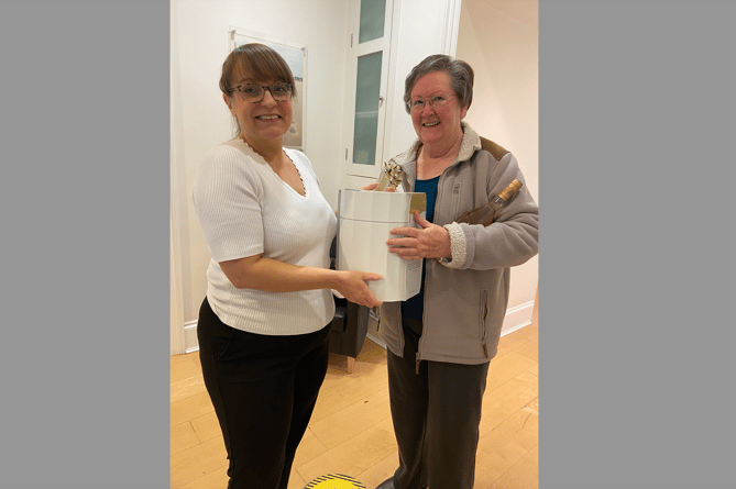 Clinic Assistant, Anna, present Carol Preston with her prize.