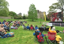 Crowds at Powderham Castle watch the coronation of King Charles III