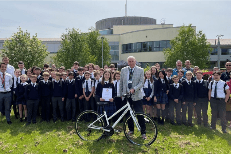 Beatrice Stothert, the 100,000th Bikeability trainee in Devon receives a bike and certificate from Cllr Stuart Hughes
