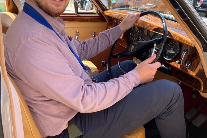 Cllr Alex Hall at the wheel of a Mk II Jaguar that caught his eye at the Newton Abbot classic vehicle show.Picture: NATC (28-5-23)