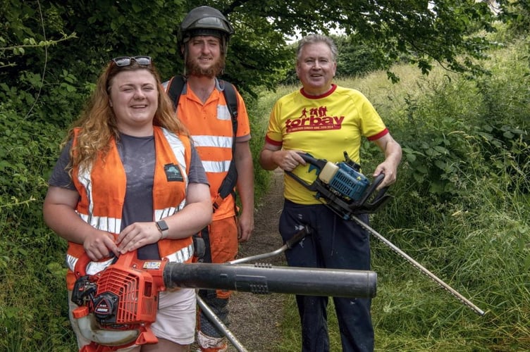 Amara Baxter, Joe Cox and Cllr David Cox clear the overgrown footpath