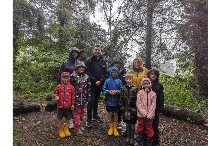 Josh and Mandy from Helpful Holidays (centre) with some of the staff and students at Chagford Primary School, in their Woodland School setting