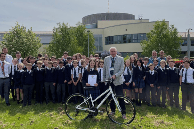Beatrice Stothert, the 100,000th Bikeability trainee in Devon receives a bike and certificate from Cllr Stuart Hughes