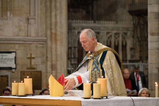 Bishop Robert laying his mitre on the altar at his farewell service at Exeter Cathedral.