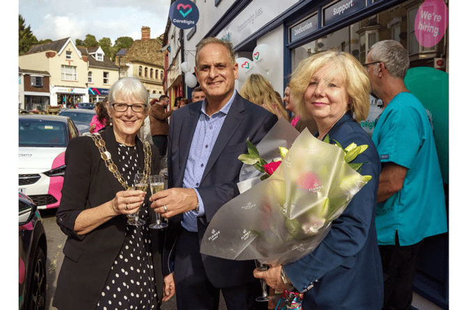 Manny Hussain shares a toast with Cllr Brooke and presents Ingrid Andrews with a celebration bouquet.
