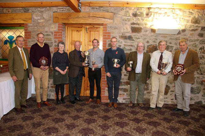Donald Tonkin, fifth left, receiving the Devon County ploughing champion trophy from, fourth left, President Raymond Govier, pictured with other trophy winners with chairman Desmond Jenkin left, and third left, secretary, Sarah Hammett.  AQ 2750
