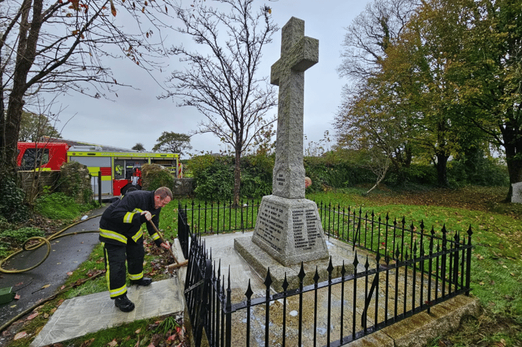 Buckfastleigh firefighters cleaning the town's war memorial ahead of Remembrance Sunday