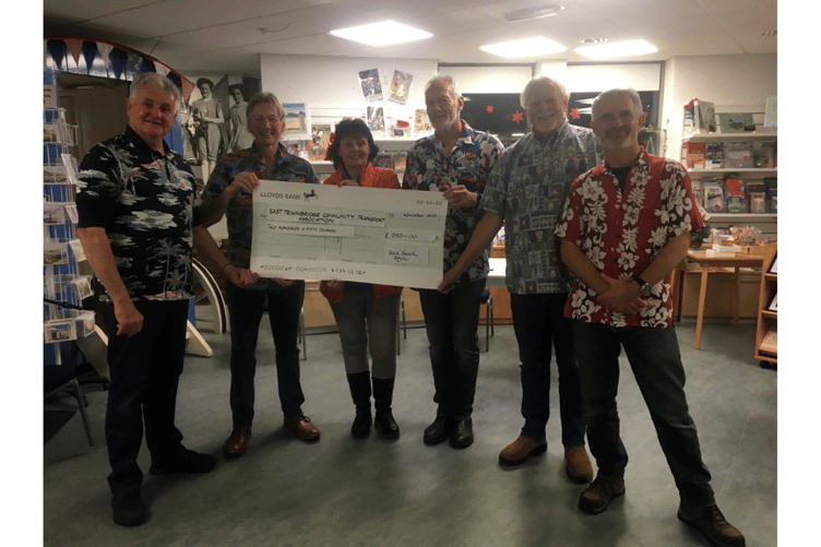 Back Beach Boyz present Dawlish Community Transport with cheque