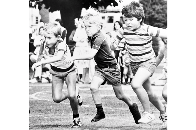 Determination on the face of these young competitors as they sprint for the finish line in a race on children’s sports day.