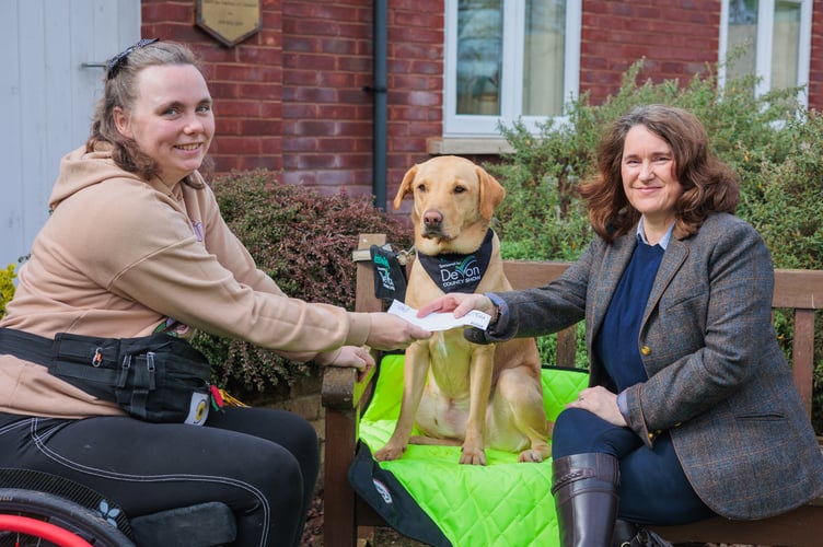 Lisa Moore, Show Manager of the Devon County Show, presents Chloe Hammond with a £1,000 cheque towards the upkeep of her assistance dog Ocho.