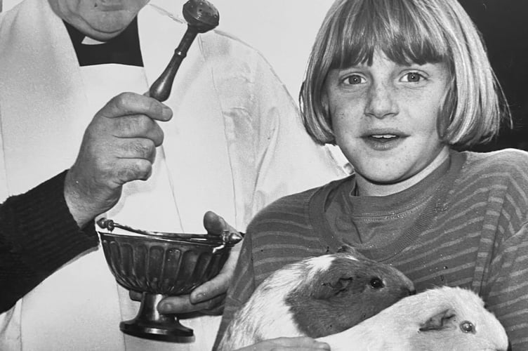 October 1995. Pet blessing at the Church of the Holy Spirit in Bovey Tracey. Father Michael Murphy blesses guinea pigs Pin and Pinny, along with their owner Jorely Badger from Lustleigh
