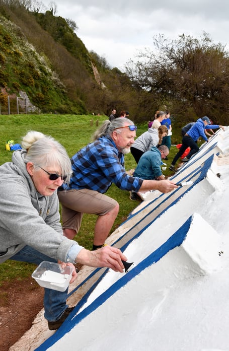 Volunteers hard at work with their paintbrushes at the Teignmouth Letters