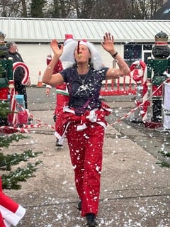 A Santa celebrates finishing the Bovey Santa Dash 