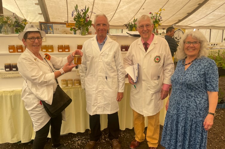 In the Beekeeping marquee, from left, Judge Suzette Perkins from Langport, Somerset, steward Chris Carr and judges Peter and Marian Guthrie from Brecon, Mid Wales.  AQ 2814