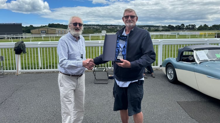 Frank Loft presents Will Edwards with the Best in Show award at the Newton Abbot Racecourse Antiques Fair and Classic Car Show