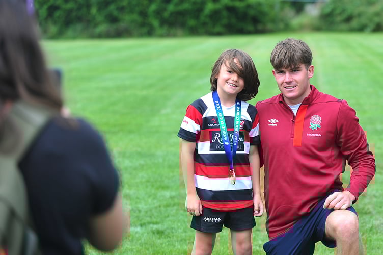 Ben Coen, of England's  Under-20 World Rugby Championship winning team, with young members of Teignmouth Rugby Club