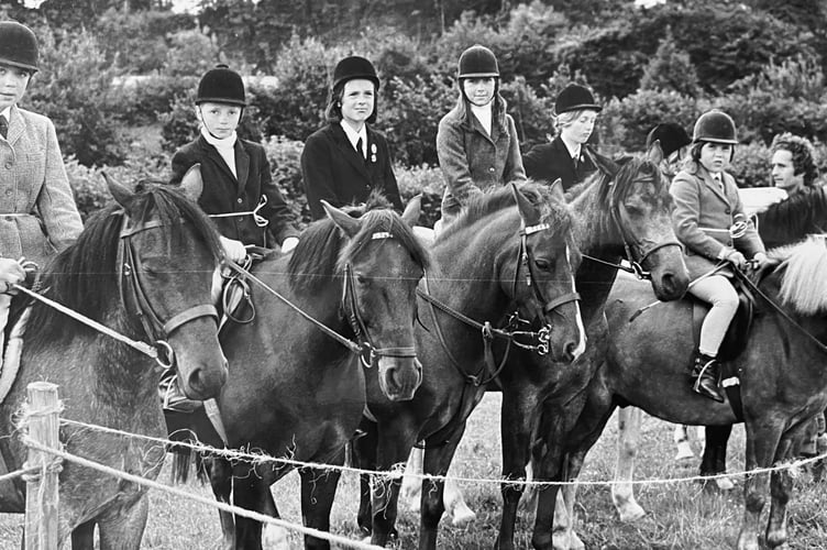 Young competitors and their mounts await their turn in the main ring for showjumping at Abbotskerswell Gymkhana held in July 1973