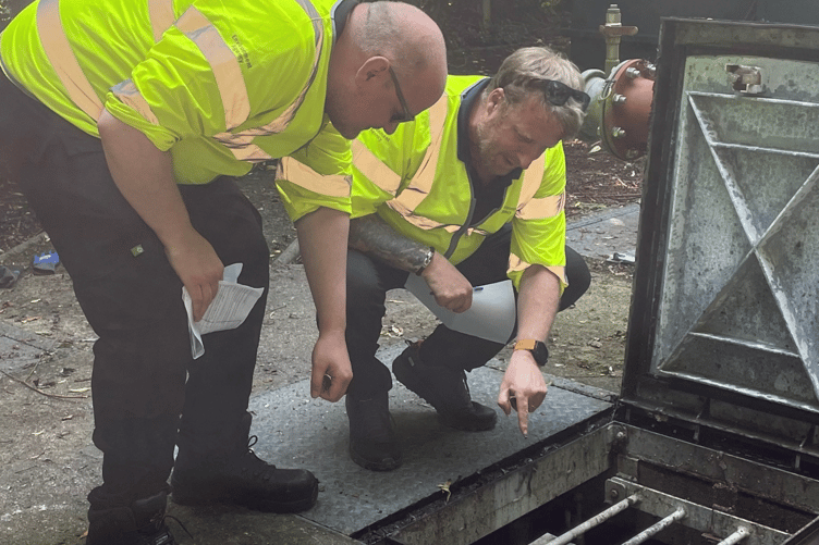Environment officers inspecting the wet well at a pumping station to make sure all pumps, chains and floats are in good working order
