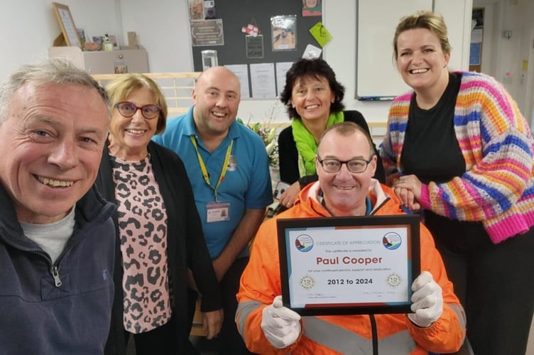 Paul Cooper proudly shows off his certificate of appreciation from Dawlish Community Transport