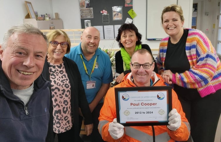 Paul Cooper proudly shows off his certificate of appreciation from Dawlish Community Transport