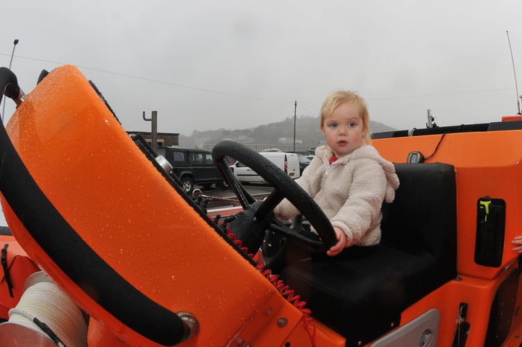 Teignmouth RNLI open boat house to let the public meet the new B-Class Atlantic 85 lifeboat Claude and Kath.  Two yrear old Rosie Mahon takes the helm