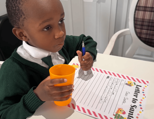 OLSP pupil Nate Kapito considers his Christmas wish list, with help from residents at The White House care home.