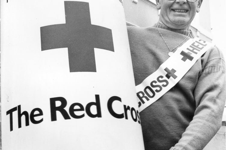 Red Cross Week 1986 in Newton Abbot and appeal organiser Leslie Scull manhandles a beast of a collecting tin 