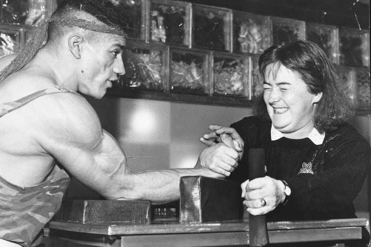 Arm wrestling championship held at the First and Last Pub in Teignmouth in mid-November 1990. Anne Bell from Teignmouth gets some practice in with British professional champion armwrestler Rod 'Rambo' Lenette