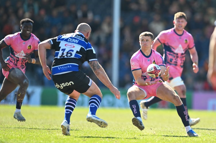 Exeter Chiefs fly-half Harvey Skinner looks to offload the ball as Bath's Tom Dunn closes in
