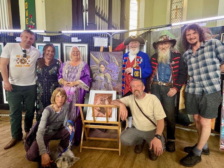 Luke Steffens at his exhibition with dad Brian, wife Caz, fellow artists and Dawlish Town Crier Bob Graham and his wife Heather. PHOTO BOB SIMPSON
