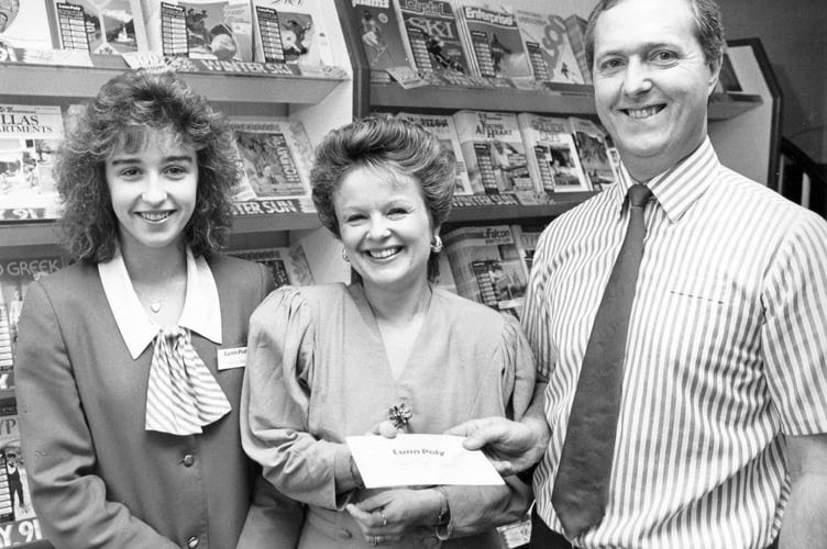 Happy holidays! Prize winner Marion Flockton receives her Lunn Poly holiday vouchers from the Teignmouth branch manager Colin Davey and travel advisor Katie Price in November 1990