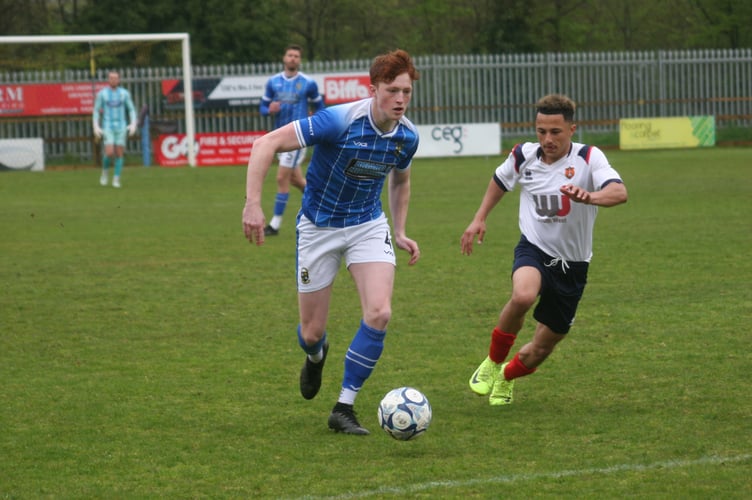 Buckland defender Rafael Beadman under pressure from Wellington's Phil Mendonca