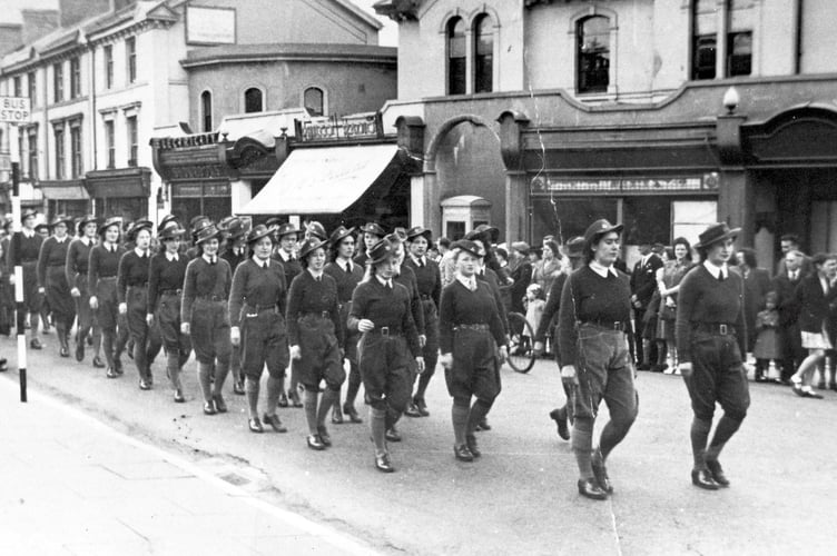 VE Day celebrations from May 1945. Land Army members march up Queen Street in Newton Abbot as part of the victory parade
