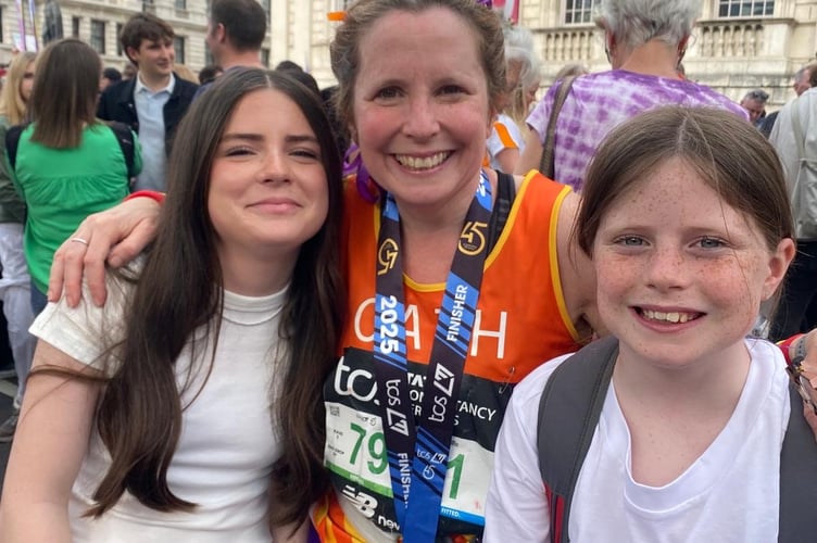 Cath Merrick celebrating completing the TCS London Marathon with her daughters.