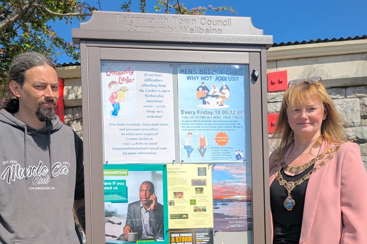 Councillor Dan Comer and Teignmouth mayor Cate Williams unveil the wellbeing board by the railway station