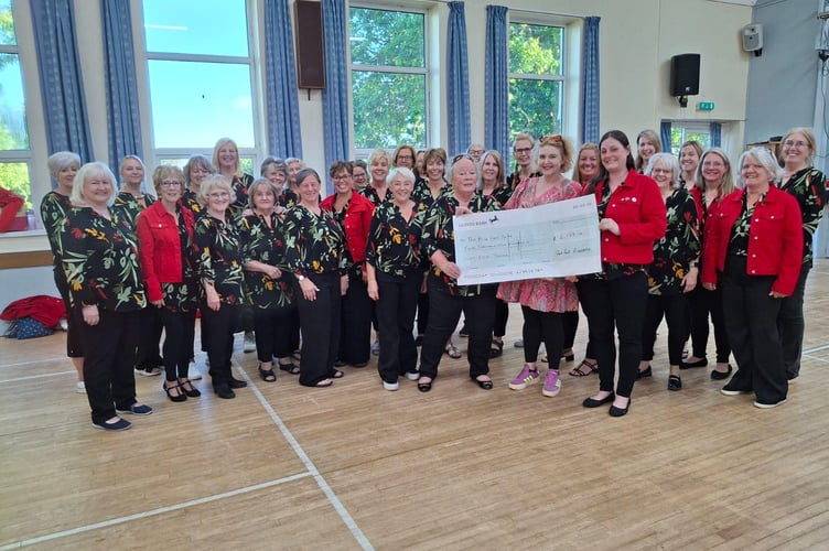 Red Rock A Cappella presenting a cheque for £2,168 to Peta Howell from the Alice Cross Centre