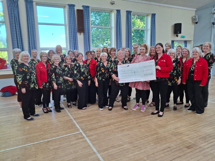Red Rock A Cappella presenting a cheque for £2,168 to Peta Howell from the Alice Cross Centre