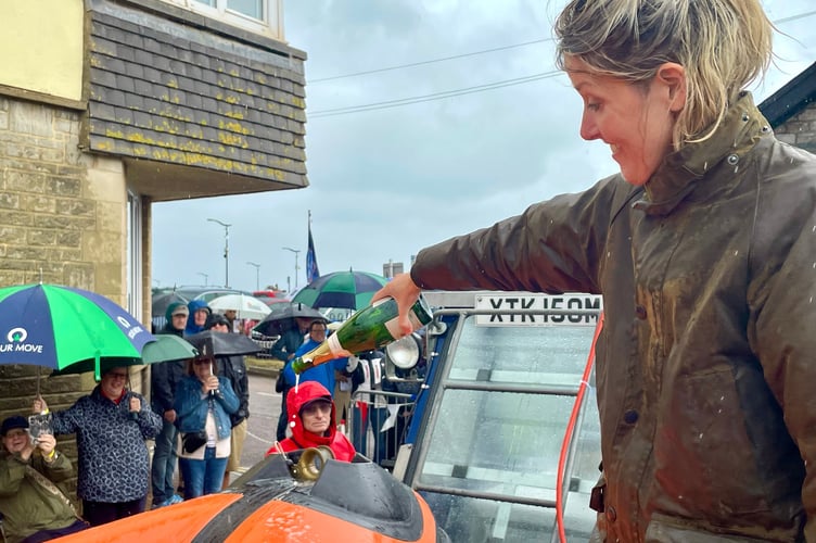 Lady Clifford of Chudleigh christens Teignmouth's new lifeboat, the Claude and Kath with a bottle of champagne.