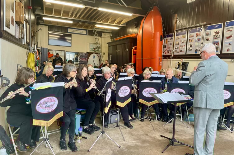 Spectrum Music sheltering in the RNLI Teignmouth boat house from the heavy rain as they performed at the naming ceremony and service of dedication for the new lifeboat, Claude and Kath