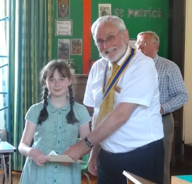 Grace Seager receives her prize for winning the Teignmouth Rotary Club Year 5-6 Junior Speaks competition at OLSP