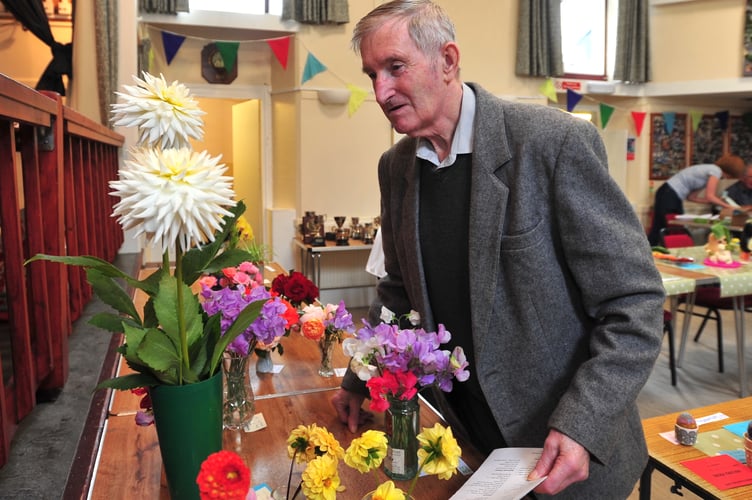 Highweek Village Show. Flower, fruits and vegetable  judge Jim Collins inspects the blooms