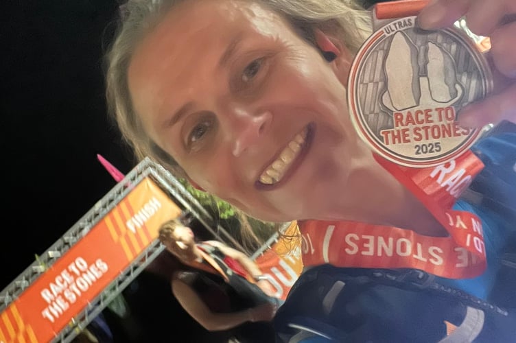 Anneliese Kesteven celebrates completing the 100km Race to the Stones ultra-marathon despite the sizzling temperatures